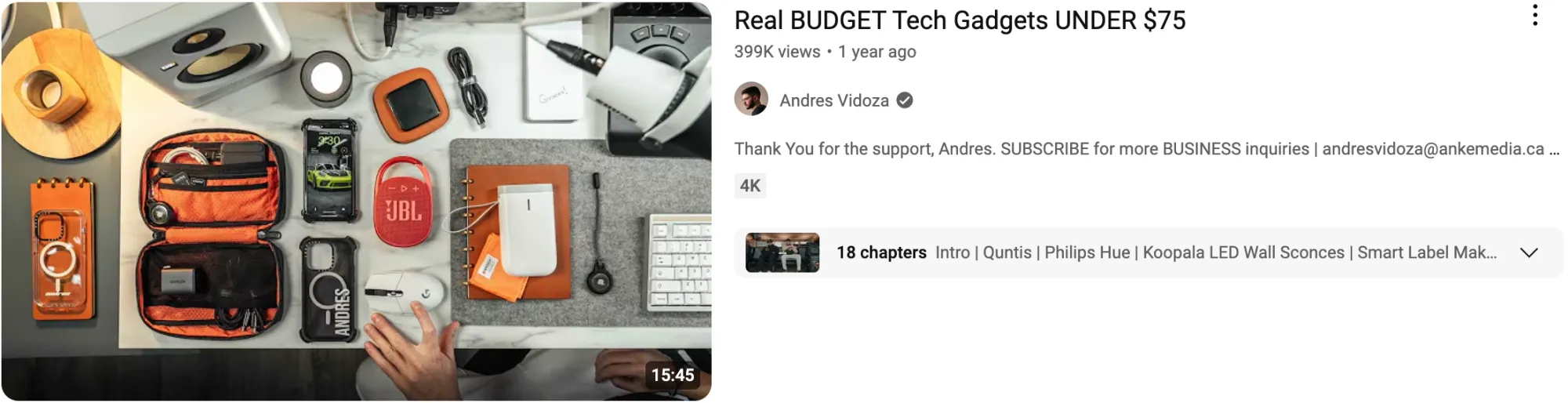 Overhead view of budget tech gadgets, including a speaker and organizer, for a video titled “Real Budget Tech Gadgets Under $75.”