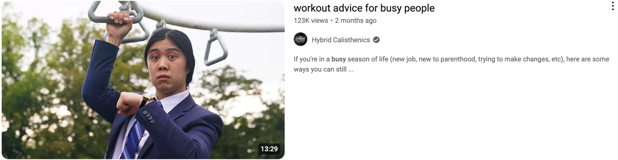 A man in a suit hangs from monkey bars for a video titled “Workout Advice for Busy People.”