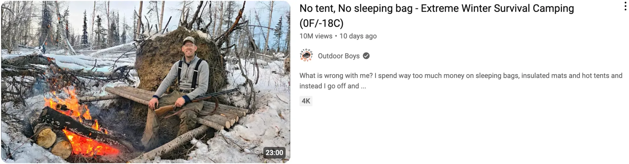 A man sits by a snowy campfire for a video titled “No Tent, No Sleeping Bag - Extreme Winter Survival Camping.”